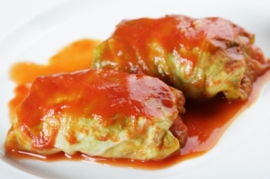 two cabbage rolls with tomato sauce on a plate